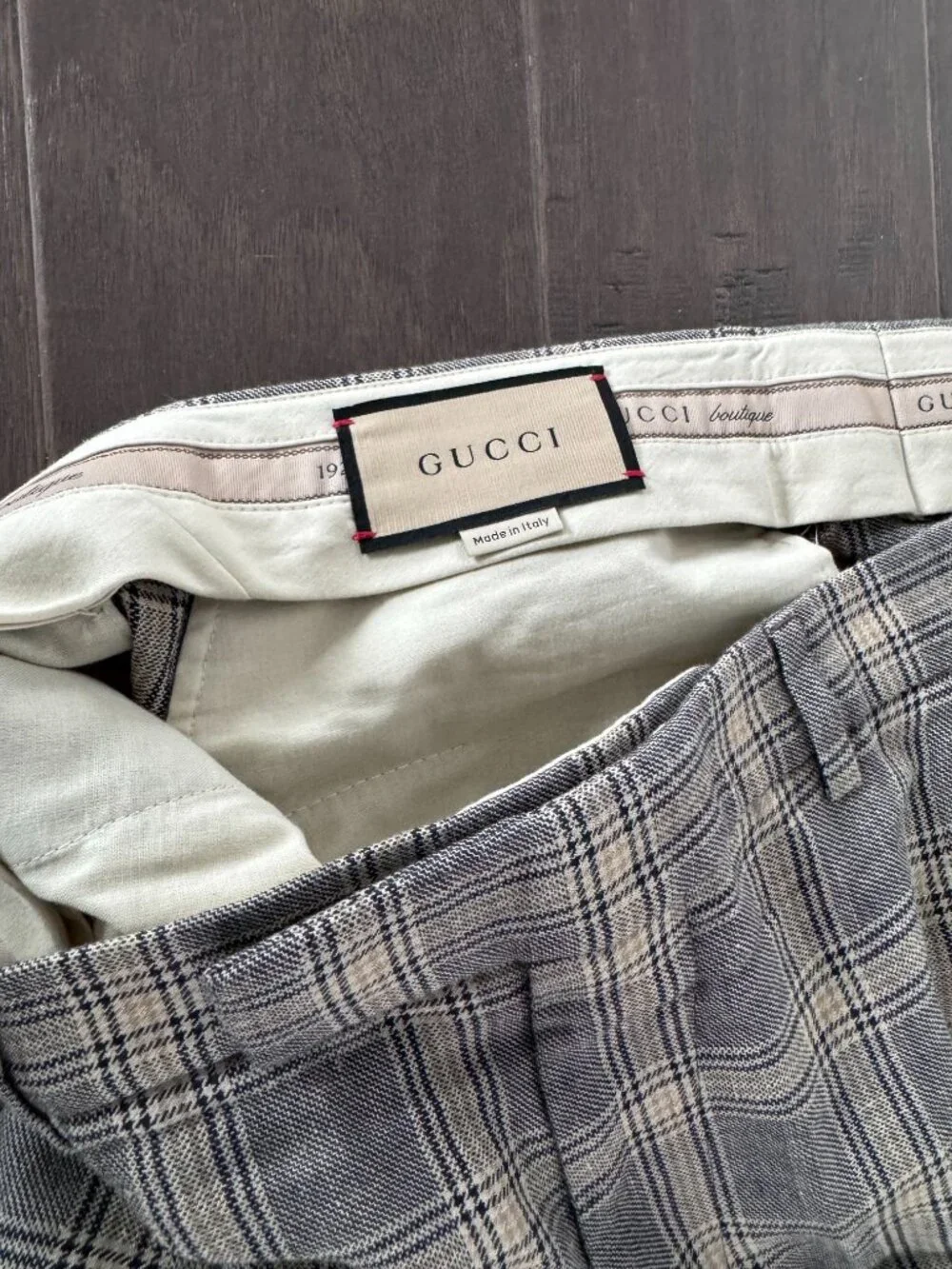 Gucci tartan pants featuring a classic check pattern in gray and beige.